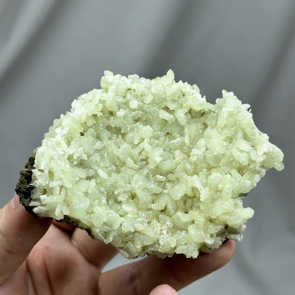 Pale green bow-tie prehnite plate with epidote from Morocco, close-up of the crystal faces