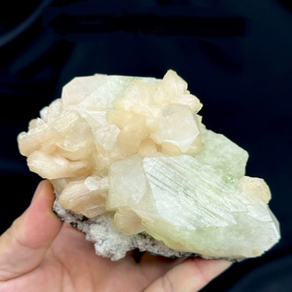 Large pale-green apophyllite crystal with peach stilbite from India, close-up of the crystal faces