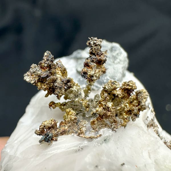 Iridescent dendritic native silver on white calcite from the USA, close-up of the crystal faces