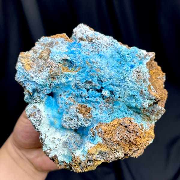 Electric-blue allophane crust in rusty rock pocket from Yunnan, China, close-up of the crystal faces