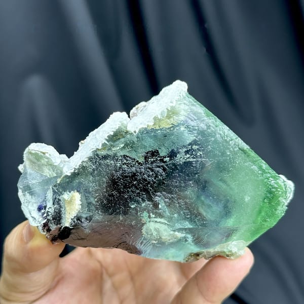 Large glassy phantom fluorite with red, green and blue layers from Inner Mongolia, China, detail of the matrix contact