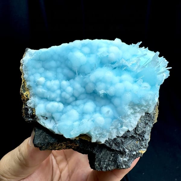 Dome of sky-blue acicular aragonite balls from Yunnan, China, held in hand