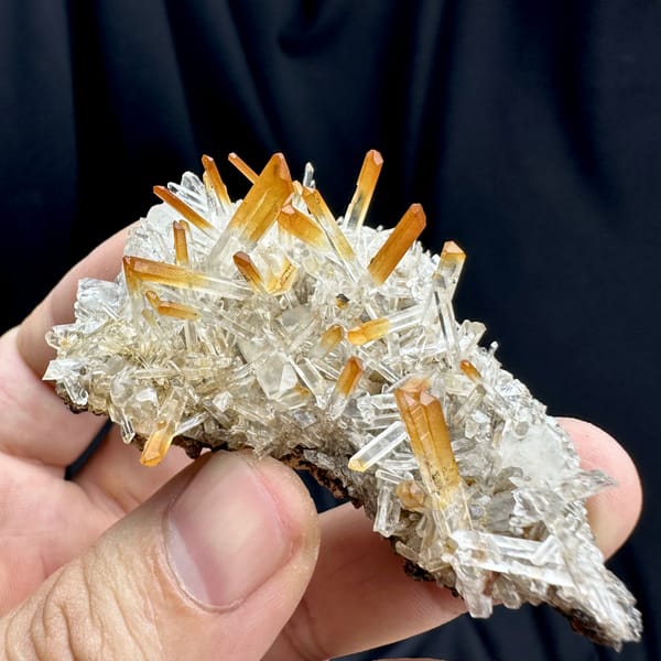 Orange-tipped clear quartz needle fan from Jinkouhe, Sichuan, China, close-up of the crystal faces