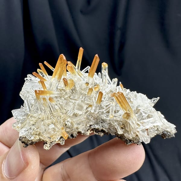 Orange-tipped clear quartz needle fan from Jinkouhe, Sichuan, China, detail of the matrix contact
