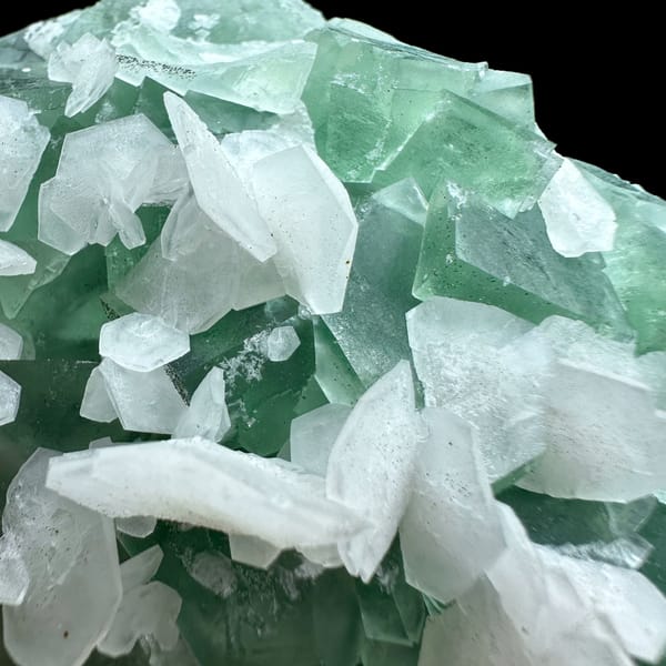 White calcite blades over mint-green fluorite from Fujian, China, close-up of the crystal faces