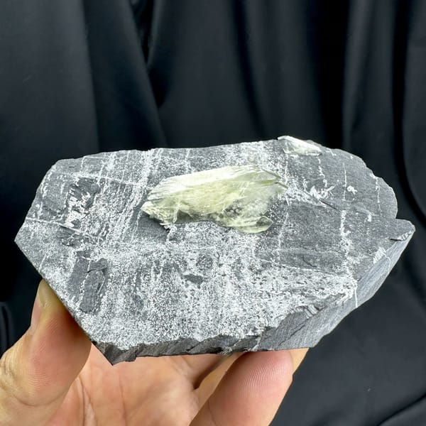 Large transparent double-terminated baryte blade on grey rock from Guangxi, China, held in hand