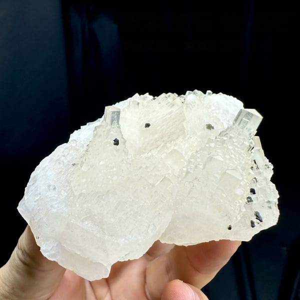 Transparent stepped tower calcite with black marmatite from Hunan, China, held in hand