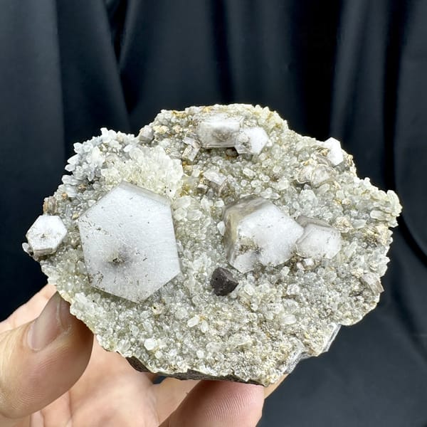 Hexagonal sandwich calcite plates with limonite on grey druse from Fujian, China, detail of the matrix contact