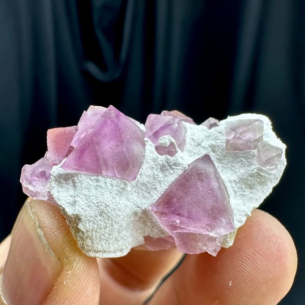 Pink fluorite octahedra on white druse stalk from Zhejiang, China, reverse side