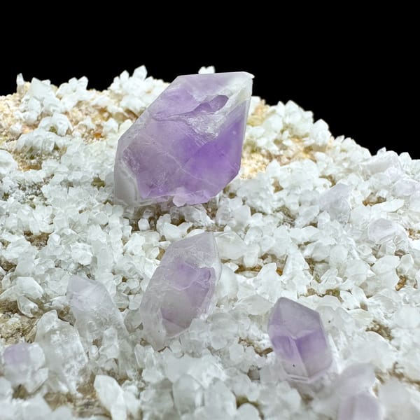Pale amethyst point standing on white feldspar plate from Yunxiao, Fujian, China, second angle