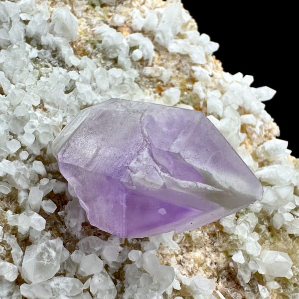 Pale amethyst point standing on white feldspar plate from Yunxiao, Fujian, China, close-up of the crystal faces