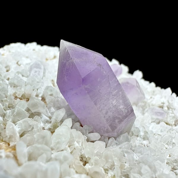 Pale amethyst point standing on white feldspar plate from Yunxiao, Fujian, China, top view