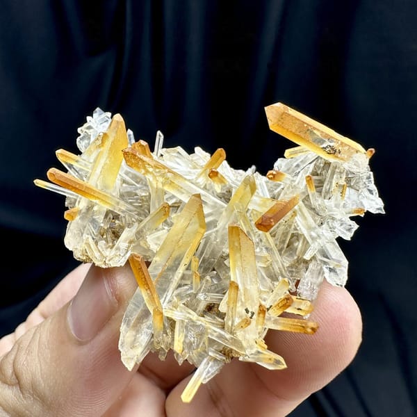 Clear quartz needles with mango-orange tips from Jinkouhe, Sichuan, China, detail of the matrix contact