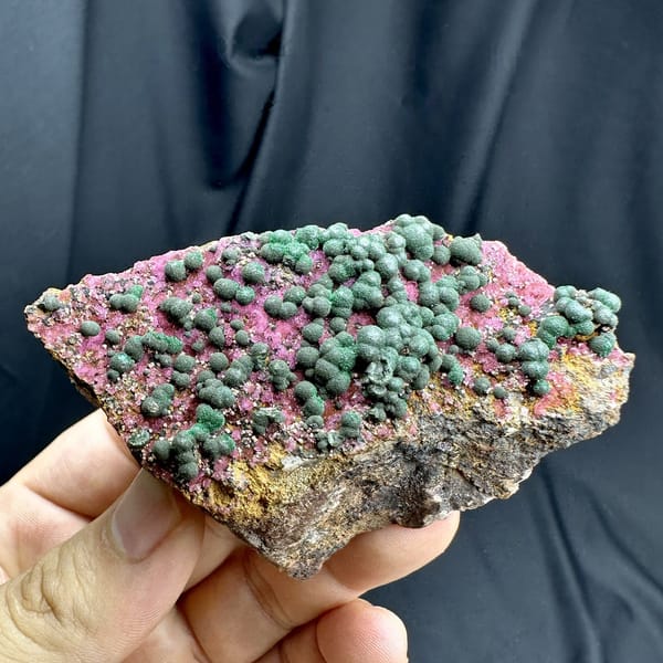 Green malachite balls over hot-pink cobaltoan calcite from DR Congo, detail of the matrix contact