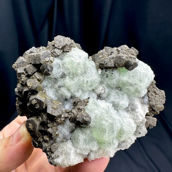 Frosted mint-green fluorite between chocolate-brown calcite from Fujian, China, close-up of the crystal faces