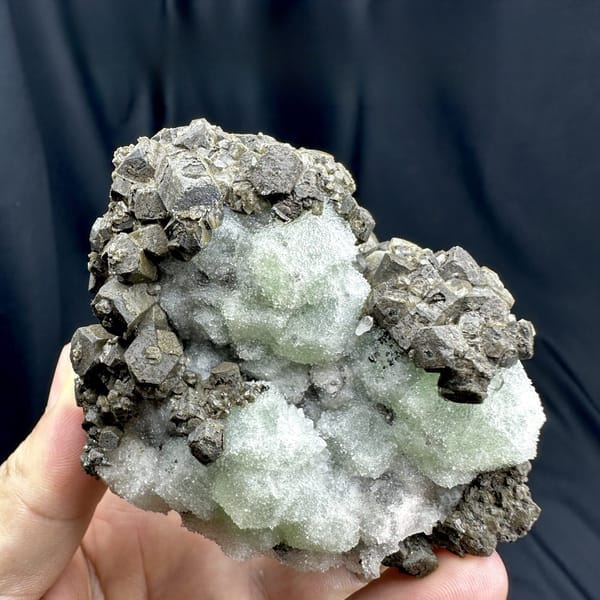 Frosted mint-green fluorite between chocolate-brown calcite from Fujian, China, detail of the matrix contact