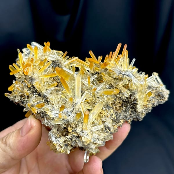 Cluster of clear quartz needles with mango-orange tips from Jinkouhe, Sichuan, China, close-up of the crystal faces