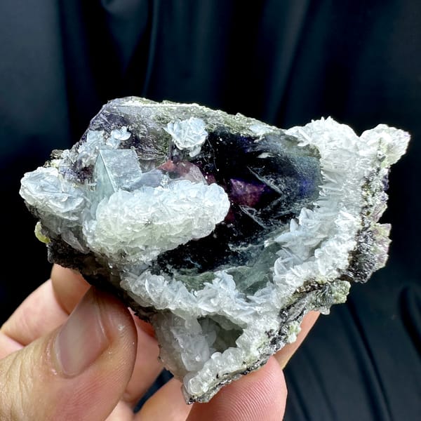 Dark phantom fluorite cube in white calcite with pyrrhotite from Inner Mongolia, China, close-up of the crystal faces