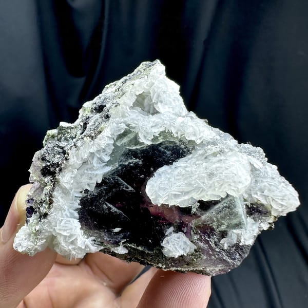 Dark phantom fluorite cube in white calcite with pyrrhotite from Inner Mongolia, China, detail of the matrix contact