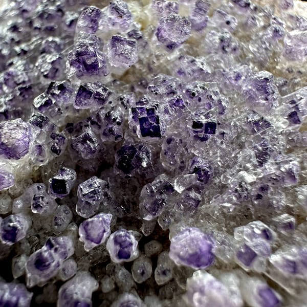 Purple yttrofluorite balls on white gypsum mound from Guizhou, China, top view