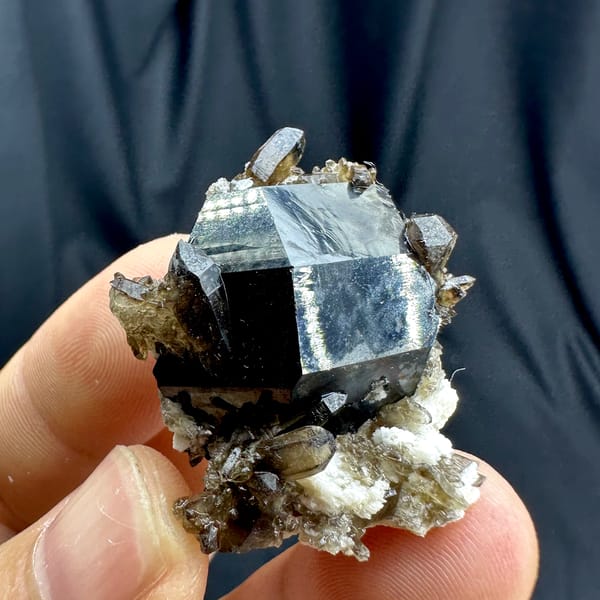 Jet-black tourmaline crystal with smoky quartz and feldspar from Namibia, top view