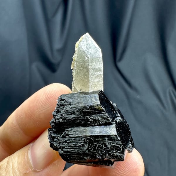 Clear smoky quartz point on black tourmaline base from Namibia, close-up of the crystal faces