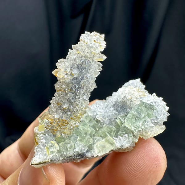 Pale green fluorite plate with quartz-druse stalk from Fujian, China, close-up of the crystal faces