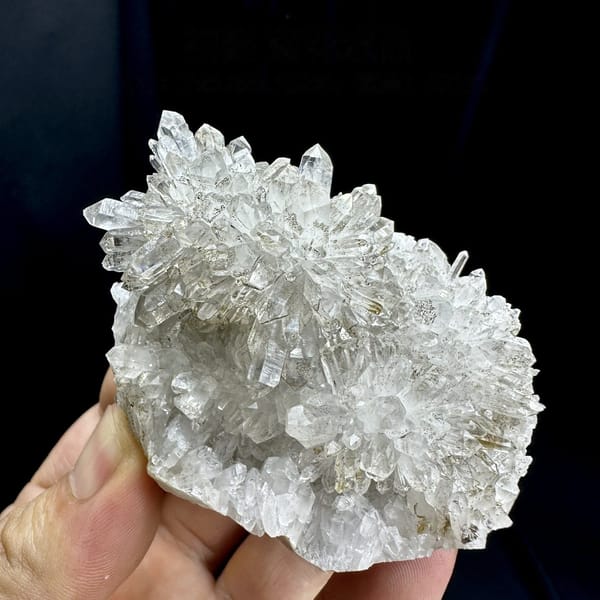 Chrysanthemum-quartz cluster of radiating clear needles from Fujian, China, detail of the matrix contact