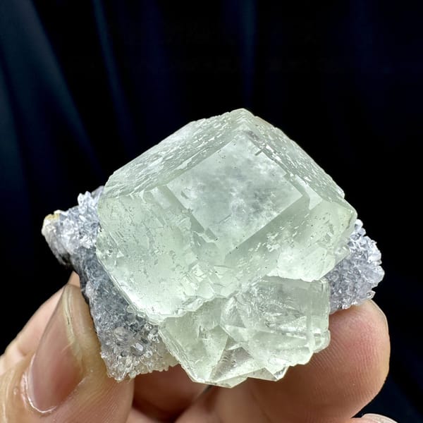 Large glass-clear pale green fluorite cube on lavender druse from Fujian, China, detail of the matrix contact