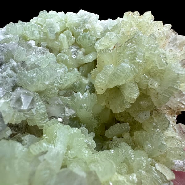 Mound of pale green fan-shaped prehnite from Morocco, close-up of the crystal faces