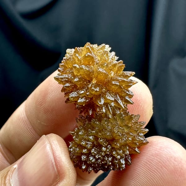 Amber calcite balls of radiating crystals from Guizhou, China, close-up of the crystal faces
