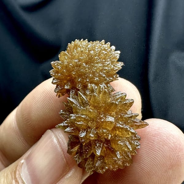 Amber calcite balls of radiating crystals from Guizhou, China, detail of the matrix contact