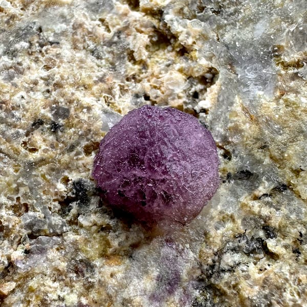 Three raspberry-pink fluorite balls on pale sandstone from Henan, China, second angle