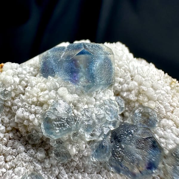 Muted teal-blue fluorite cubes on white sugar-quartz from Fujian, China, close-up of the crystal faces