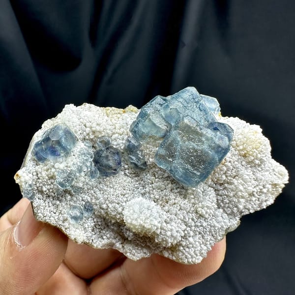 Muted teal-blue fluorite cubes on white sugar-quartz from Fujian, China, detail of the matrix contact