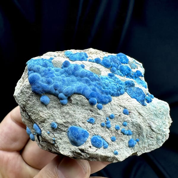 Bright blue chrysocolla balls on grey rock from DR Congo, detail of the matrix contact