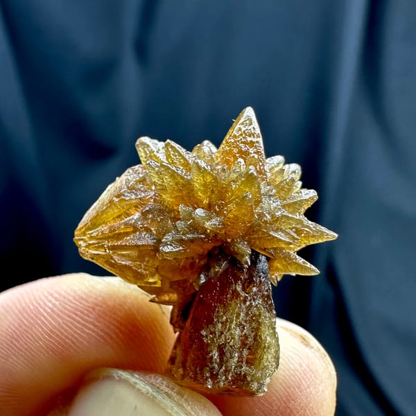 Single amber calcite flower of radiating crystals from Guizhou, China, close-up of the crystal faces