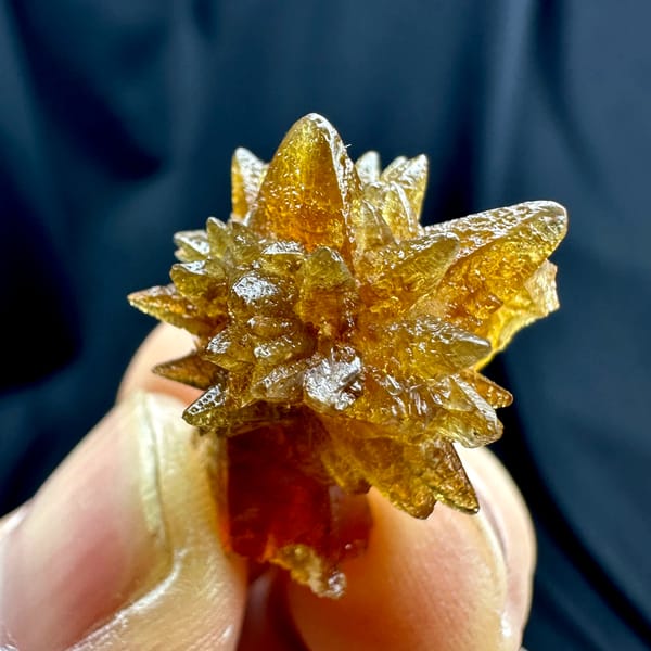 Single amber calcite flower of radiating crystals from Guizhou, China, top view