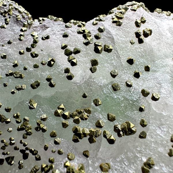 Large lavender-green fluorite floater dusted with pyrite from Jiangxi, China, close-up of the crystal faces