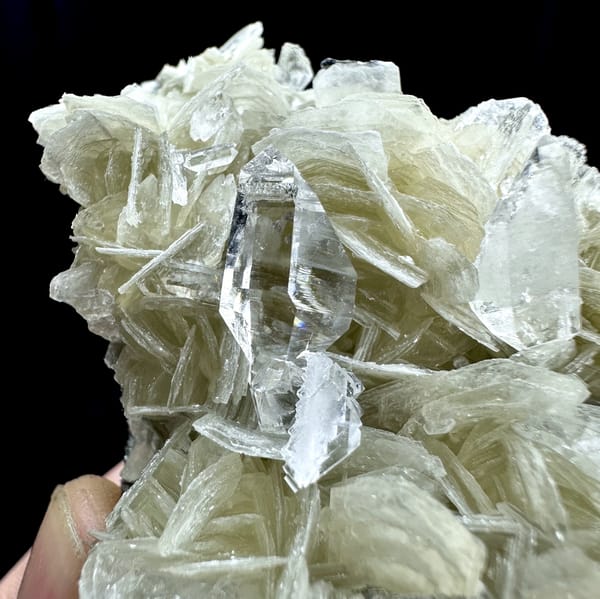 Ultra-clear quartz points among pearly muscovite from Xuebaoding, Sichuan, China, close-up of the crystal faces
