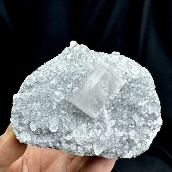 Transparent calcite prism on grey quartz druse from Fujian, China, detail of the matrix contact