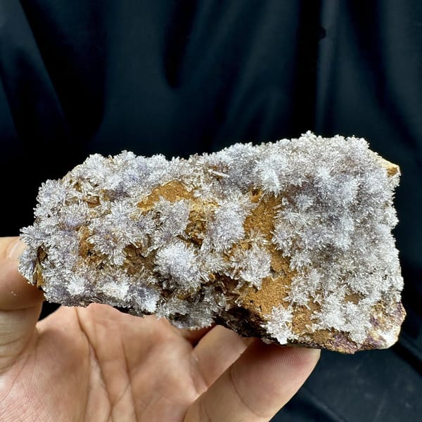 Lavender creedite flowers on ochre matrix from Guizhou, China, detail of the matrix contact