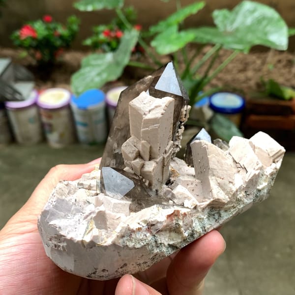 Tall smoky quartz crystal in white feldspar from Fujian, China, top view