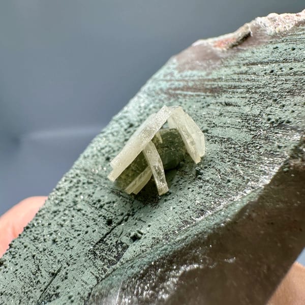 Grey hexagonal calcite plate with small white crystal and smoky quartz from Yunxiao, Fujian, China, top view