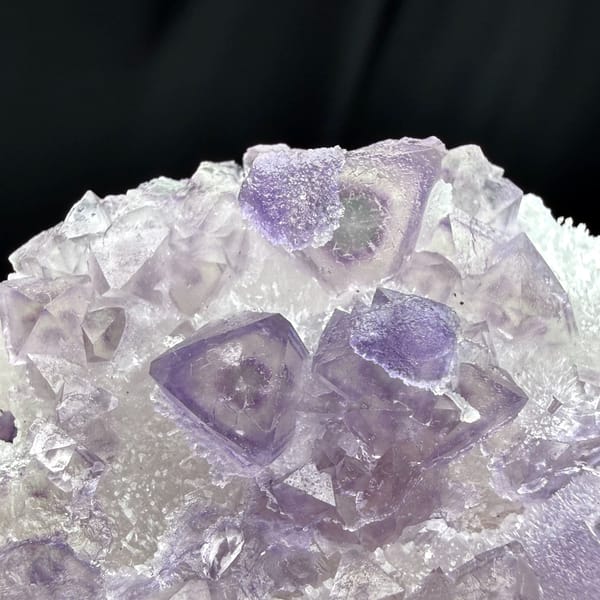 Green-core octahedral purple fluorite on quartz — detail view