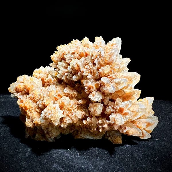 Large peach calcite cluster with sparkling crystal skins from Yunnan, China, held in hand