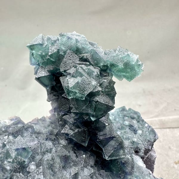 Teal-green octahedral fluorite tower on dark quartz plate from Inner Mongolia, China, reverse side