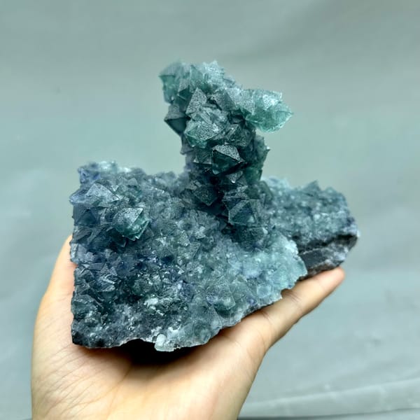 Teal-green octahedral fluorite tower on dark quartz plate from Inner Mongolia, China, side view