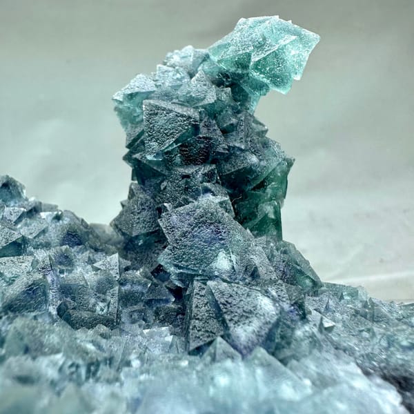 Teal-green octahedral fluorite tower on dark quartz plate from Inner Mongolia, China, overall view