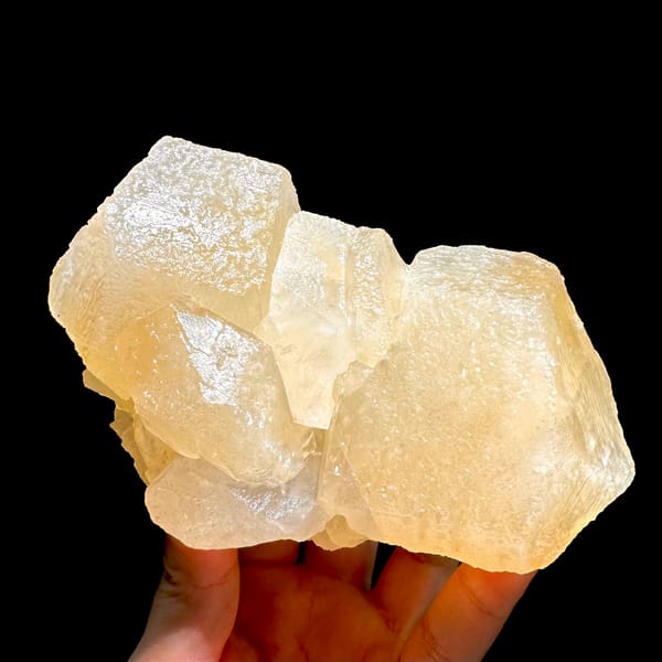Calcite cluster, from Hunan, China, front view in daylight, held in hand